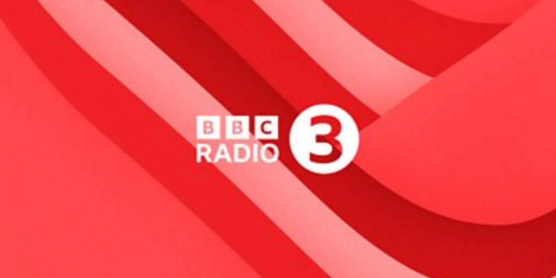 BBC Radio 3 logo, showing the BBC blocks and white 3 on a red background with smooth, curved, tonal red lines.