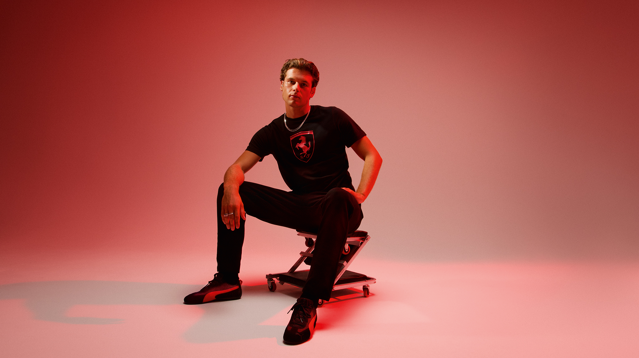 A man wearing Puma sportswear sat on a stool 