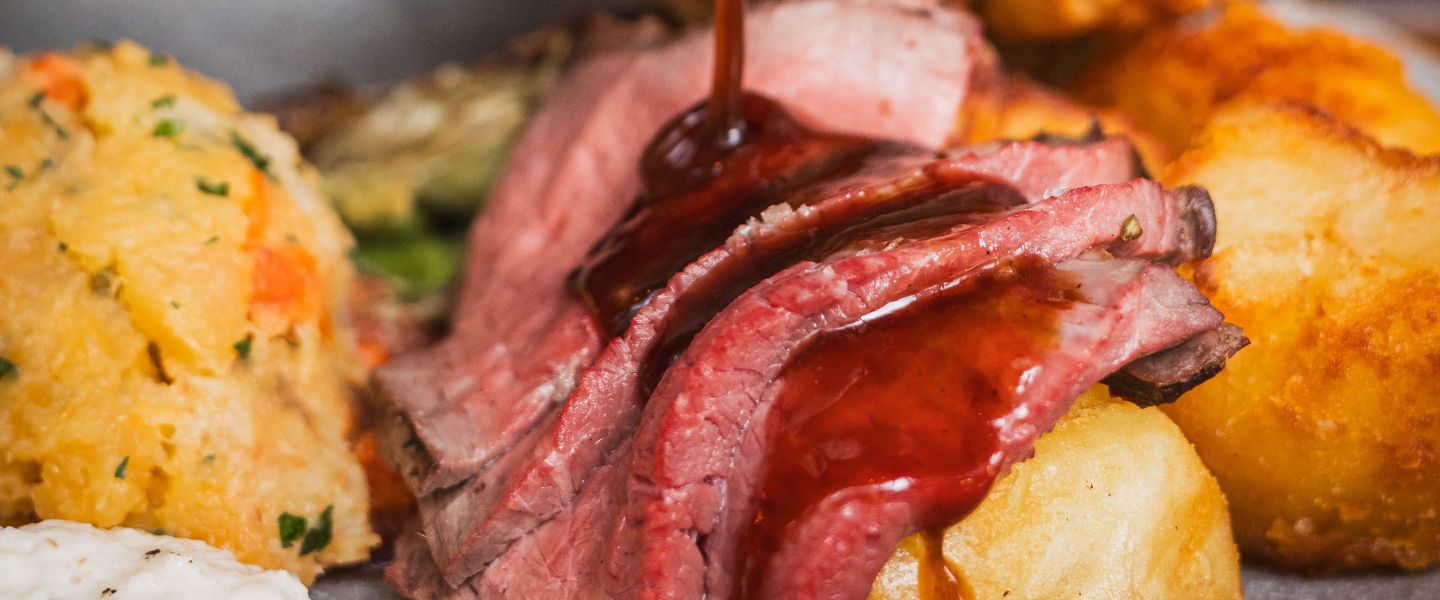 Gravy being poured over a roast dinner