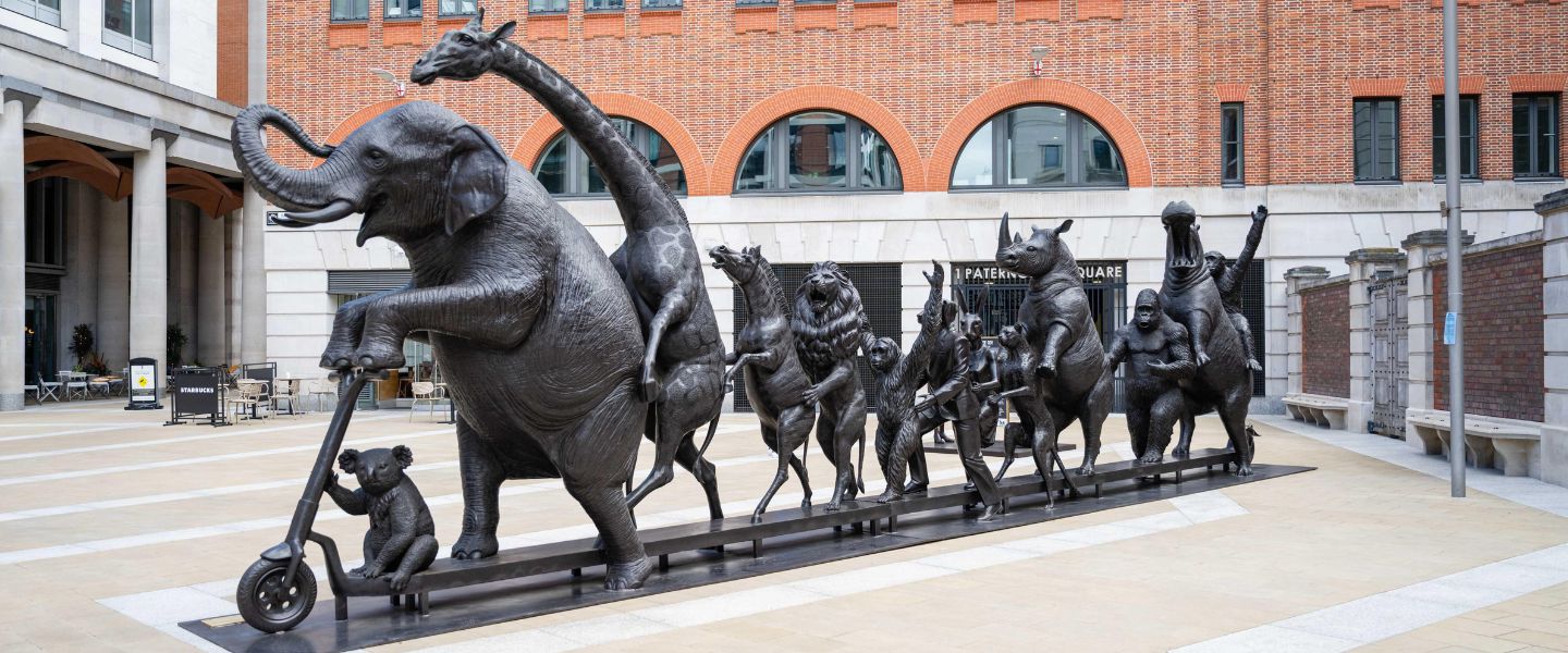 The bronze sculpture featuring wild animals on a scooter