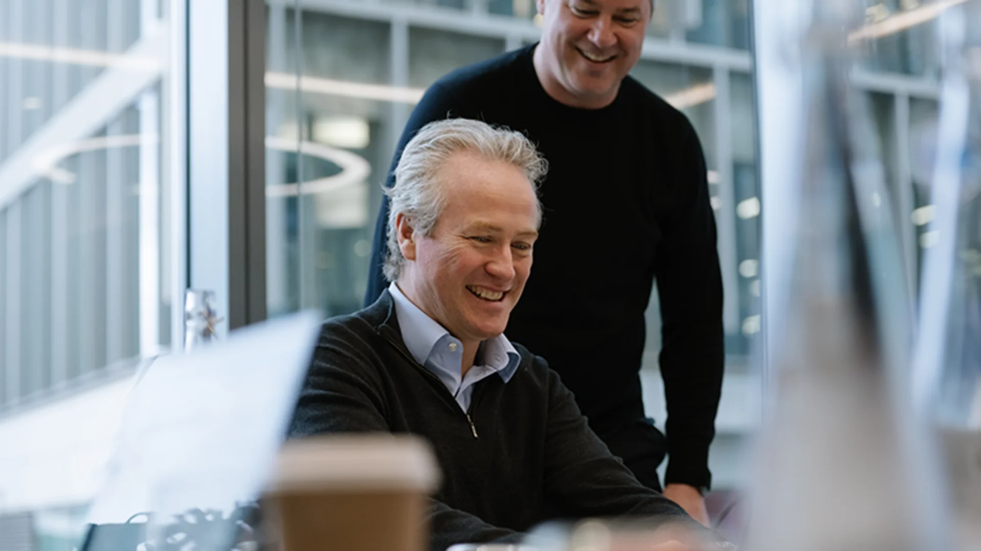 Two colleagues working together by a window.