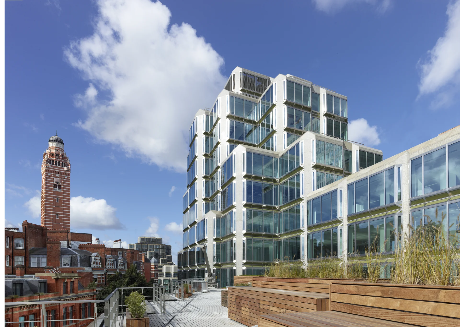 Contemporary glass office building with rooftop terrace and city view