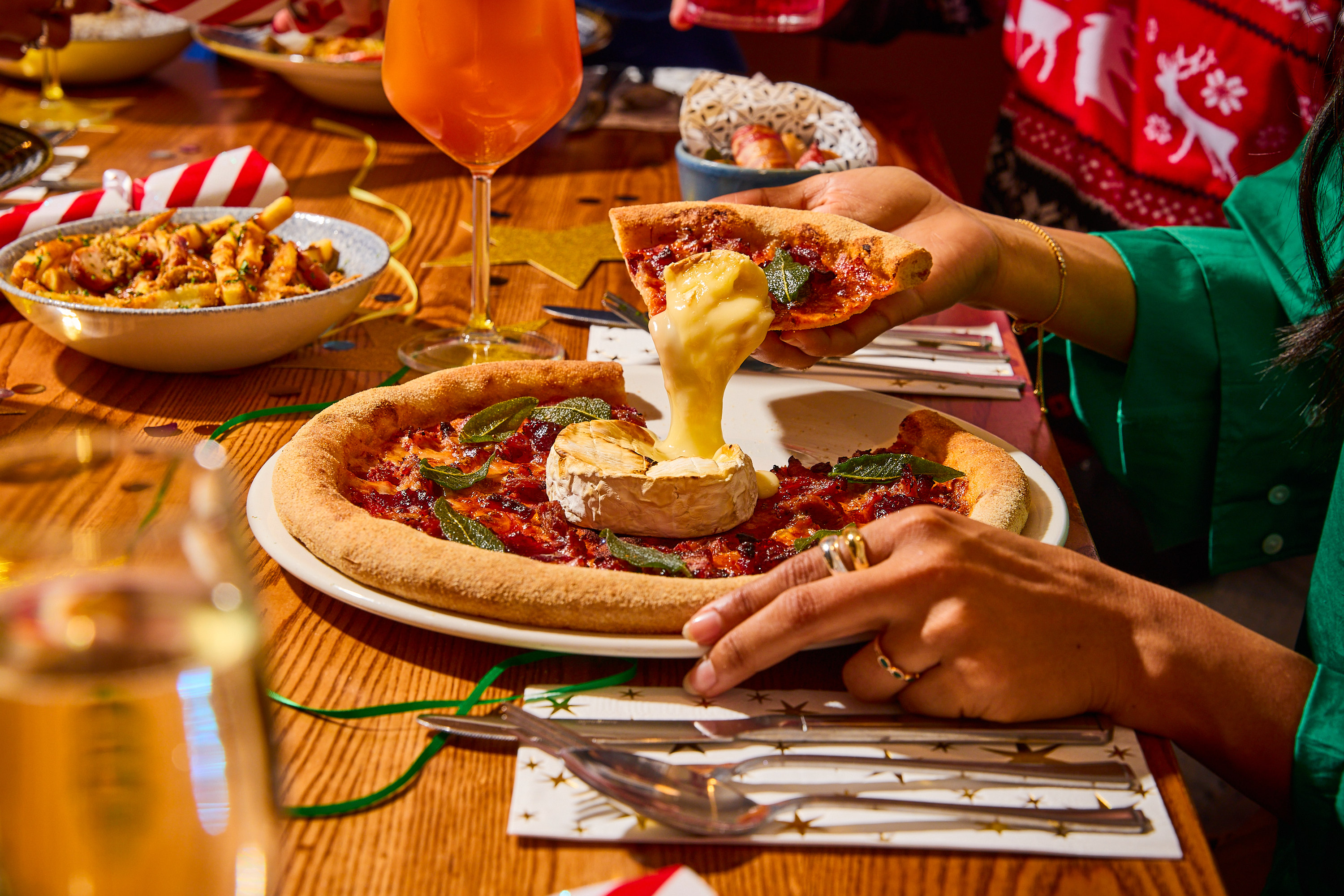 A woman enjoying a festive Christmas pizza special from Bella Italia
