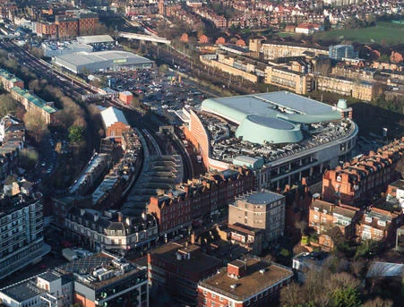 Overhead shot of a shopping center surrounded by residential buildings.