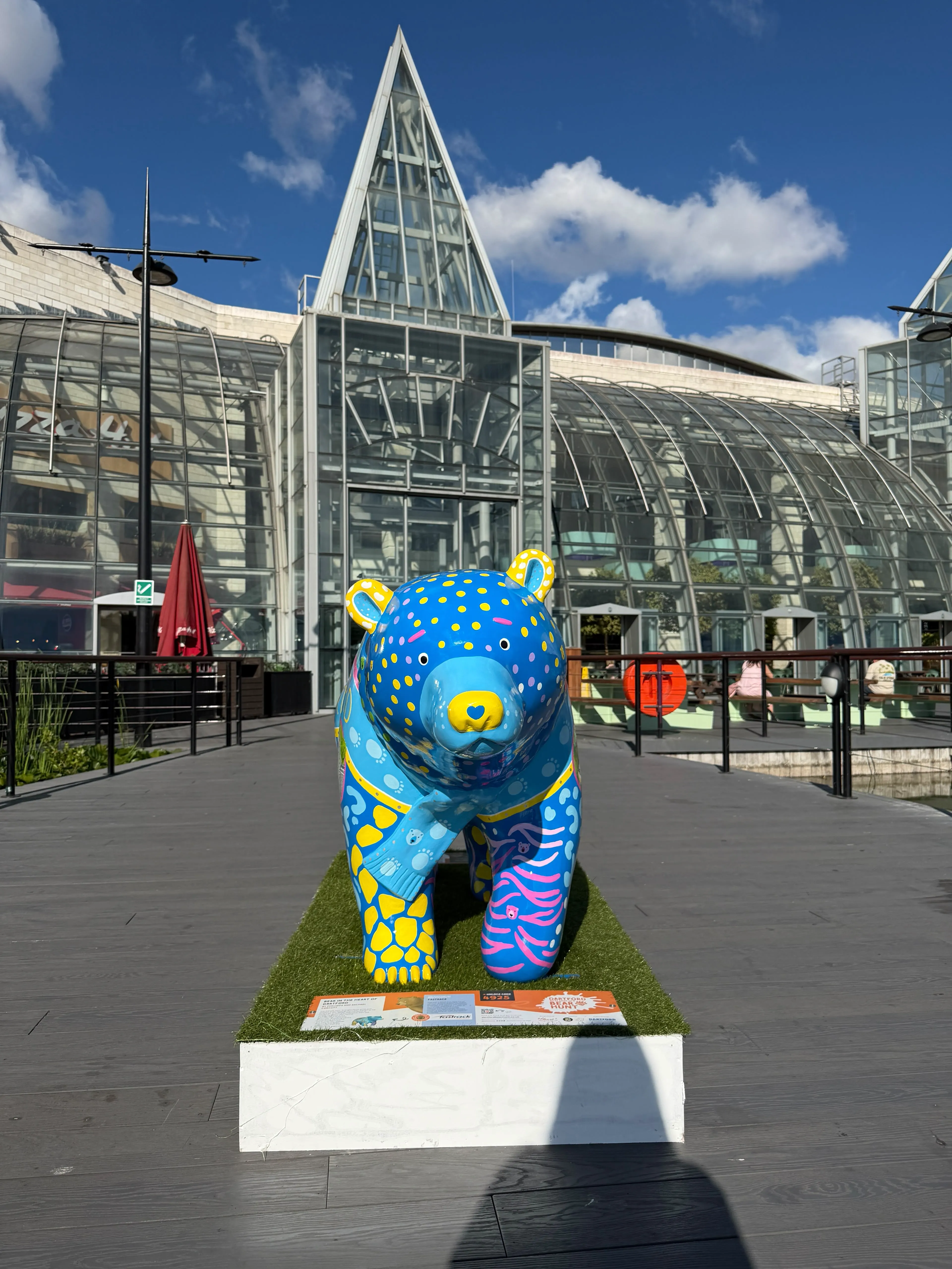 A painted bear statue stands in front of the entrance to Bluewater Shopping Centre.