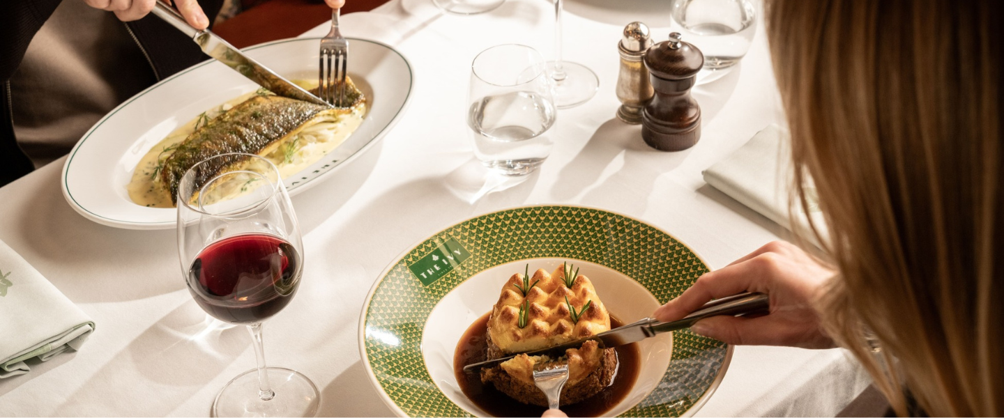 Two plates of food on a white tablecloth