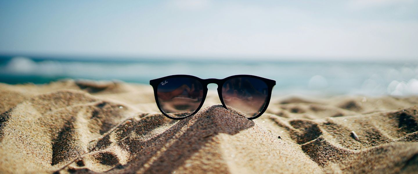 A pair of sunglasses on a sand dune