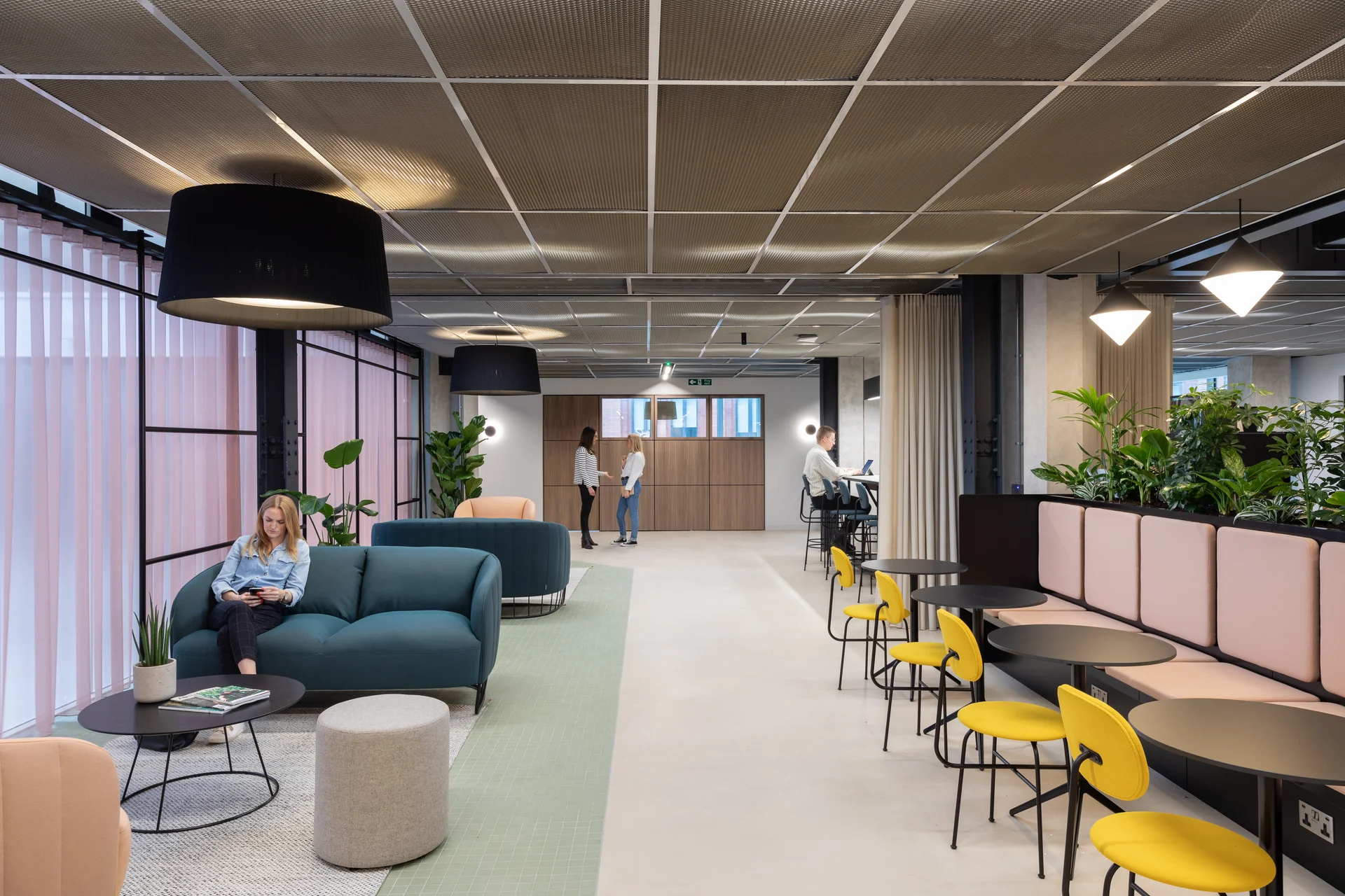 Spacious coworking area with sofas, plants, and collaborative seating