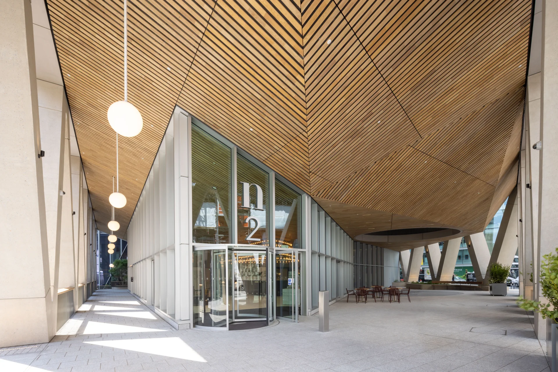 Angular glass office building with white façade and urban street scene